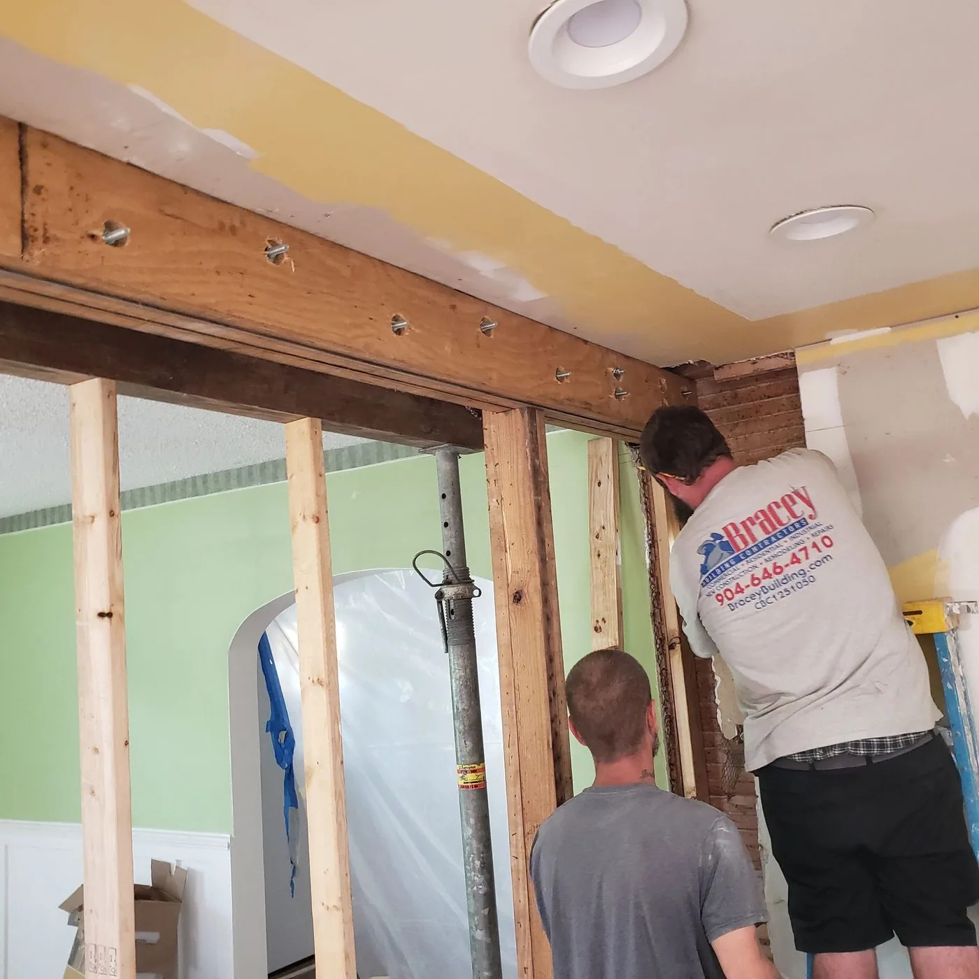 Two workers framing a new header with temporary posts holding the ceiling